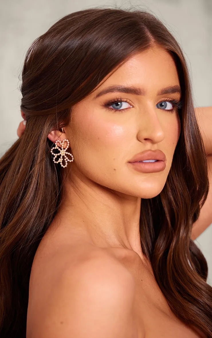 Boucles d'oreilles dorées en forme de marguerite perlées et détail clous